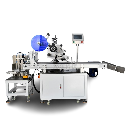 Automatic labeling machine with a blue labeling reel and conveyor belt, designed for packaging lines. The machine has a touchscreen panel and compact, durable construction.