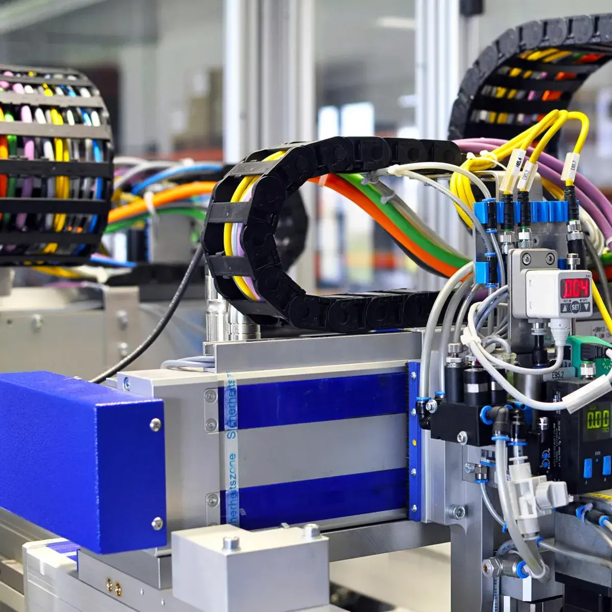 Close-up of a modern thermoforming machine featuring a complex arrangement of multicolored cables and industrial components, illustrating the intricate electrical system.