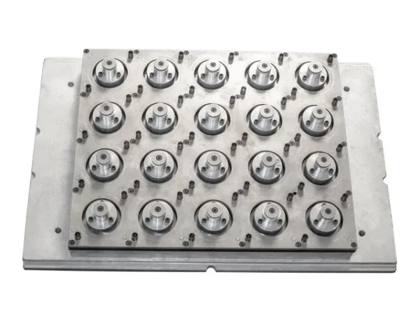 A metal punching mold used in thermoforming for producing cup lids, featuring multiple circular cavities arranged in a grid.
