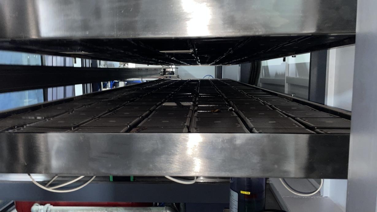 Industrial equipment interior showing the metal structure of a thermoforming machine mold with a two-platform design.