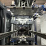 Symmetrical inside view of thermoforming machine with chain rails and vertical forming structure.